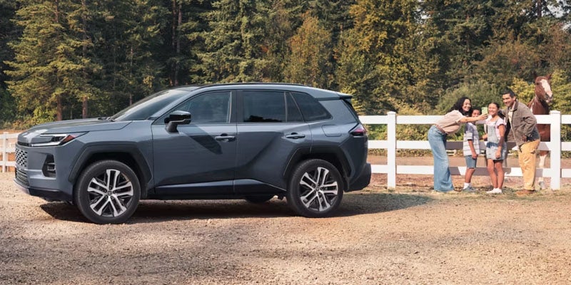 Side view of a 2026 Toyota RAV4 parked near a fence.