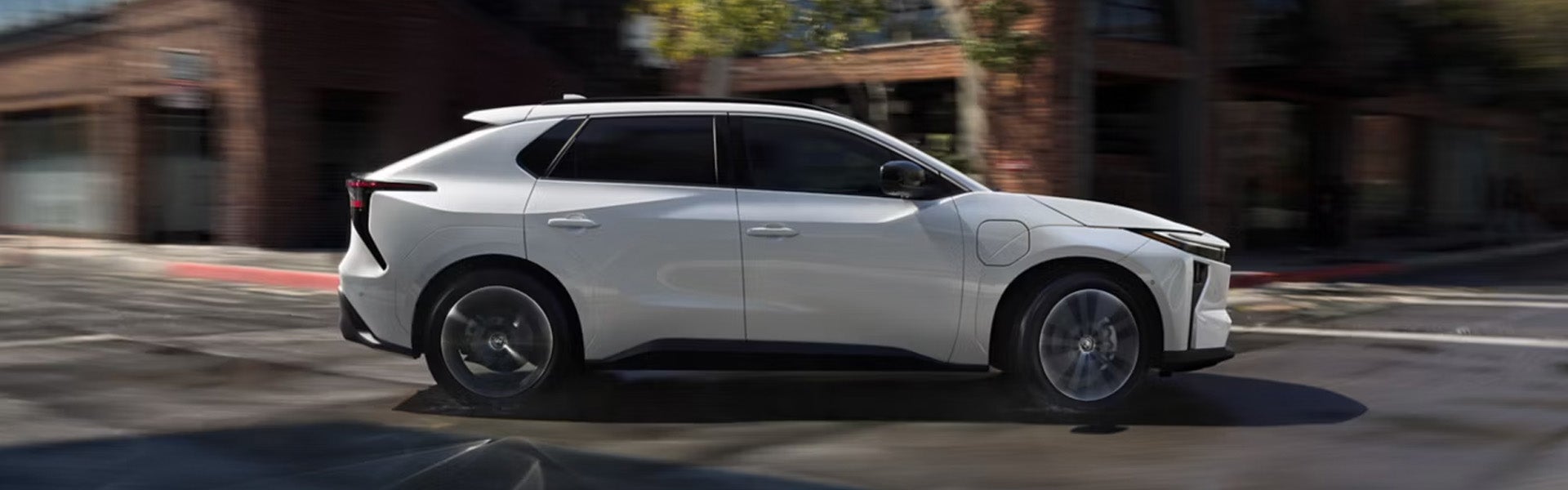 Side view of white 2026 BZ Woodland SUV in motion.