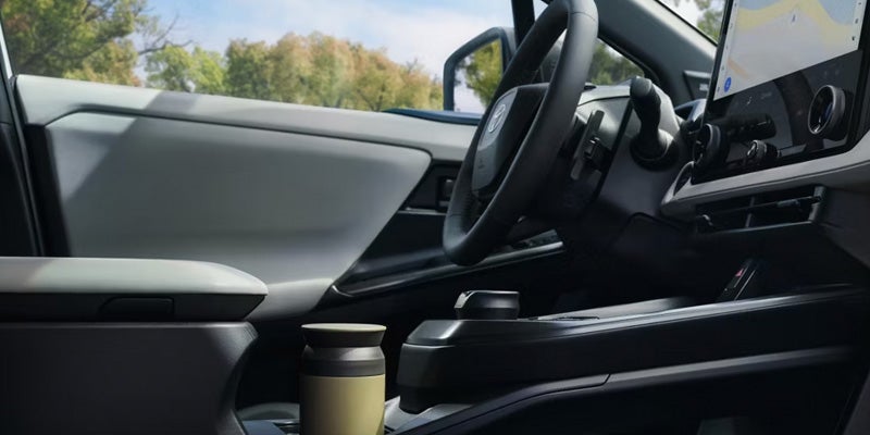 Front interior of 2026 BZ Woodland showing steering wheel, dashboard.